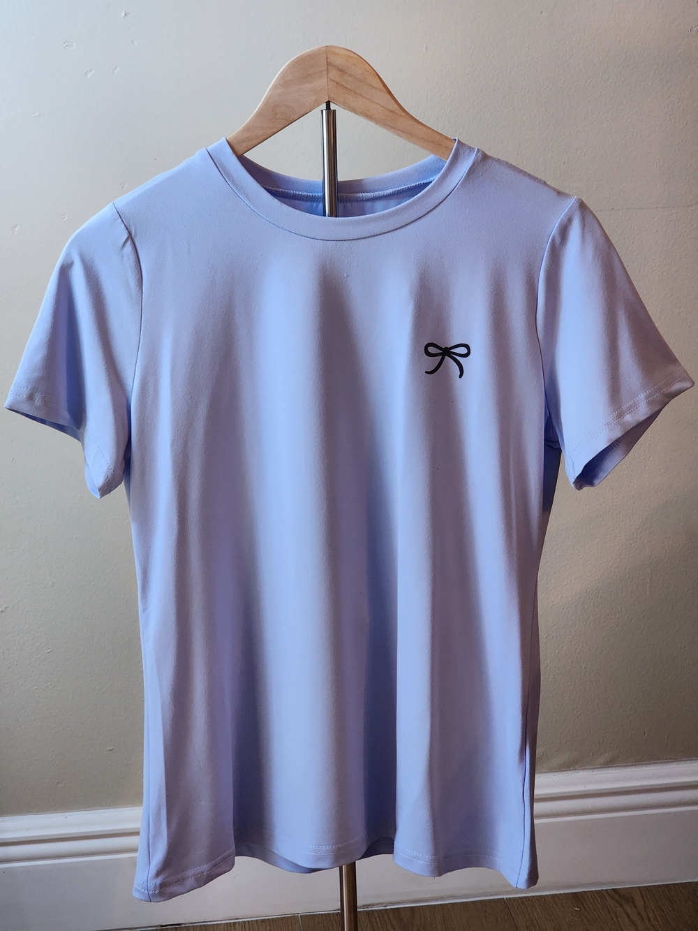 Cute and elegant pastel blue short sleeve top with a minimalist black bow detail